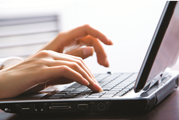 hands typing on laptop