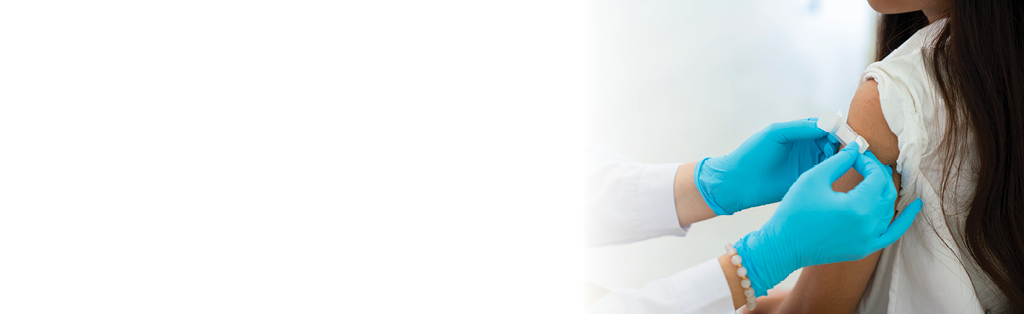 doctor putting bandaid on female patient's arm