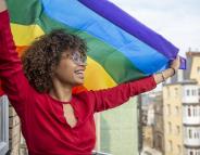 women smiling holding pride flag
