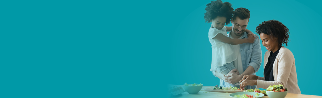 father, mother and daughter cooking a meal
