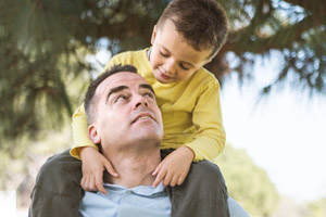 Father with child sitting on shoulders.